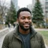 Ifeanyi smiling outdoors on a Calgary street in autumn