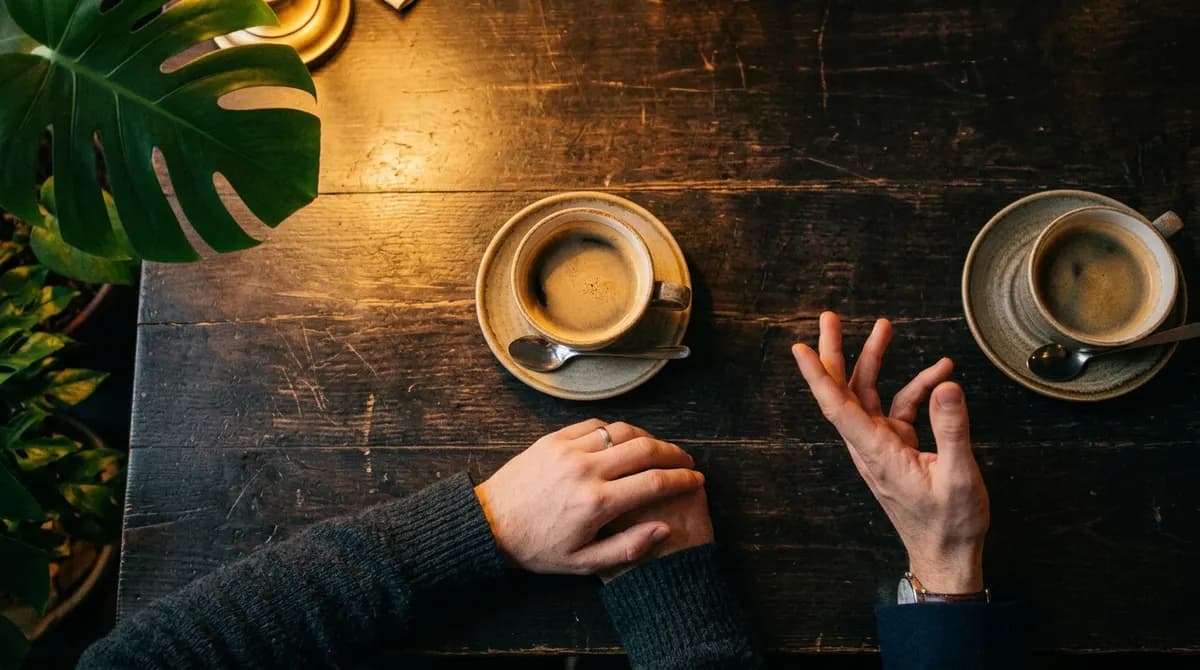 Two people talking across a small table in warm evening light